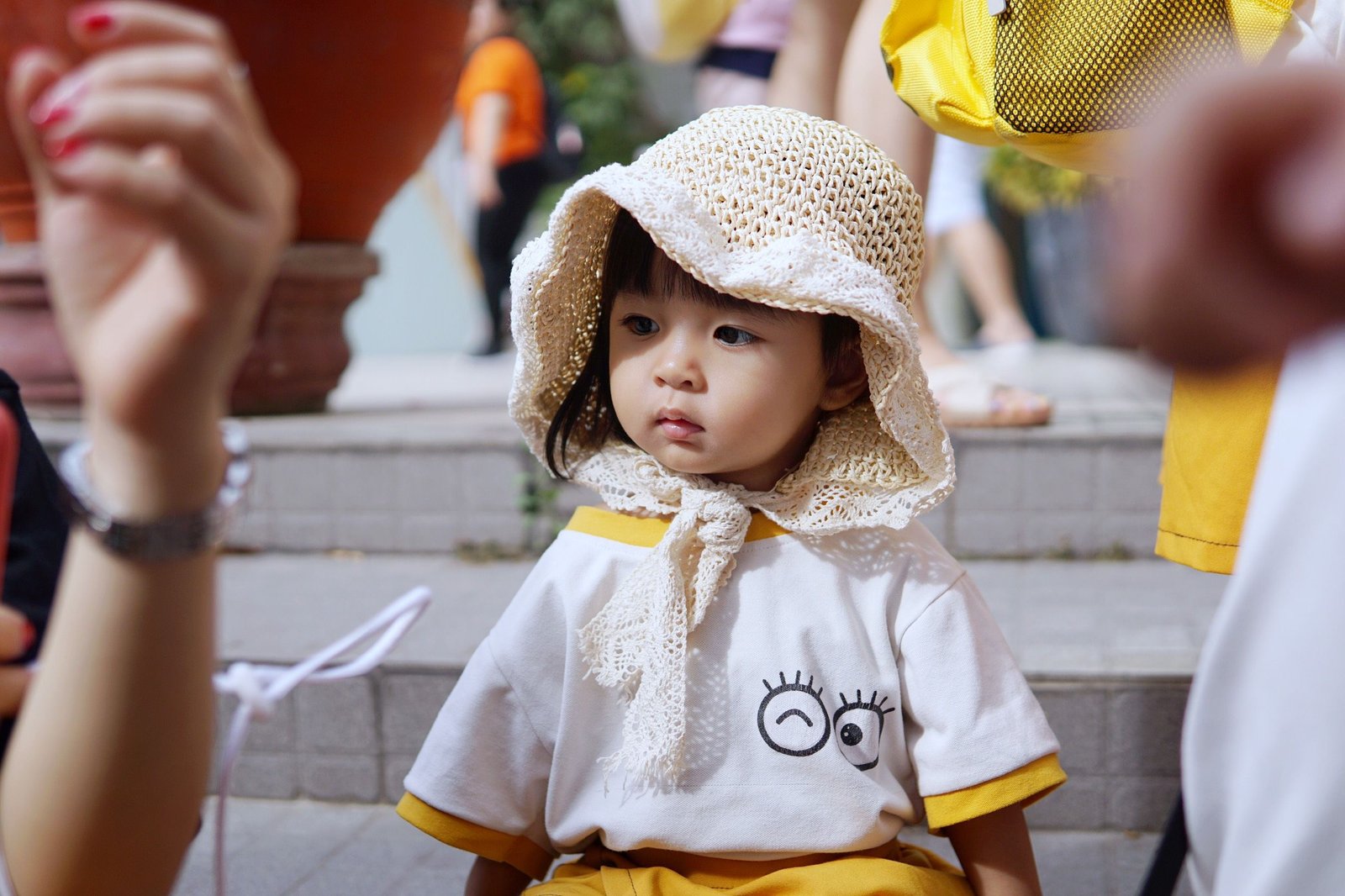 Cute little girl wearing a knitted hat and expressive t-shirt outdoors.